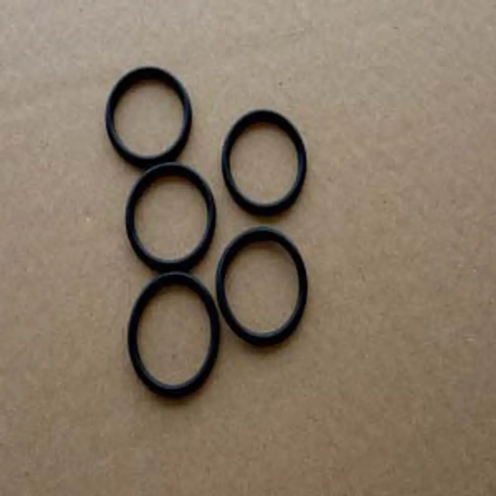 Fünf schwarze O-Ringe auf einer braunen Pappe, geeignet für Anwendungen von Remeha, um gasdichte Verbindungen herzustellen.